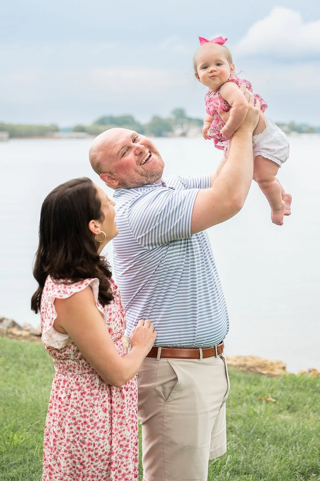 mom and day play with their baby girl during lake norman family photo session