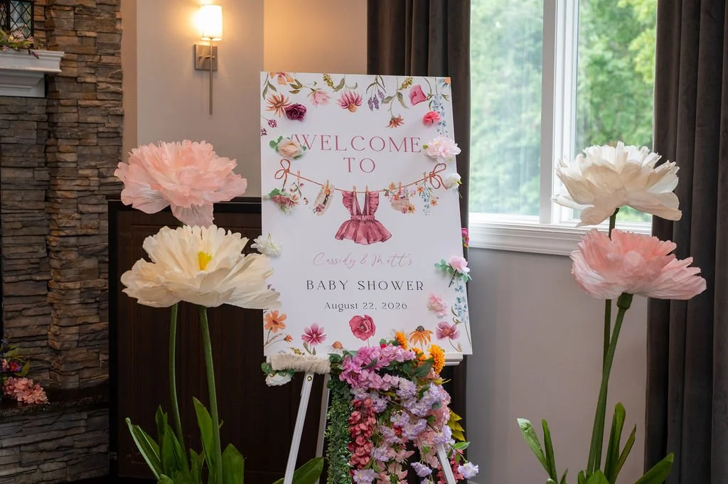 photo of baby shower sign and flower decor
