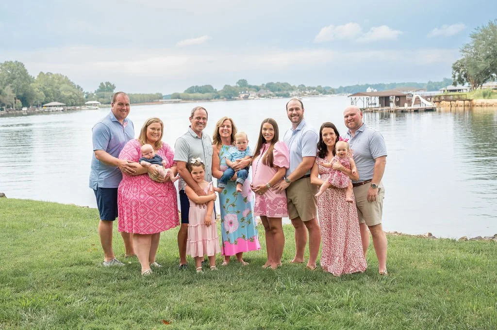 Extended family poses with grandparents, parents and children in front of lake norman during outdoor family photo session
