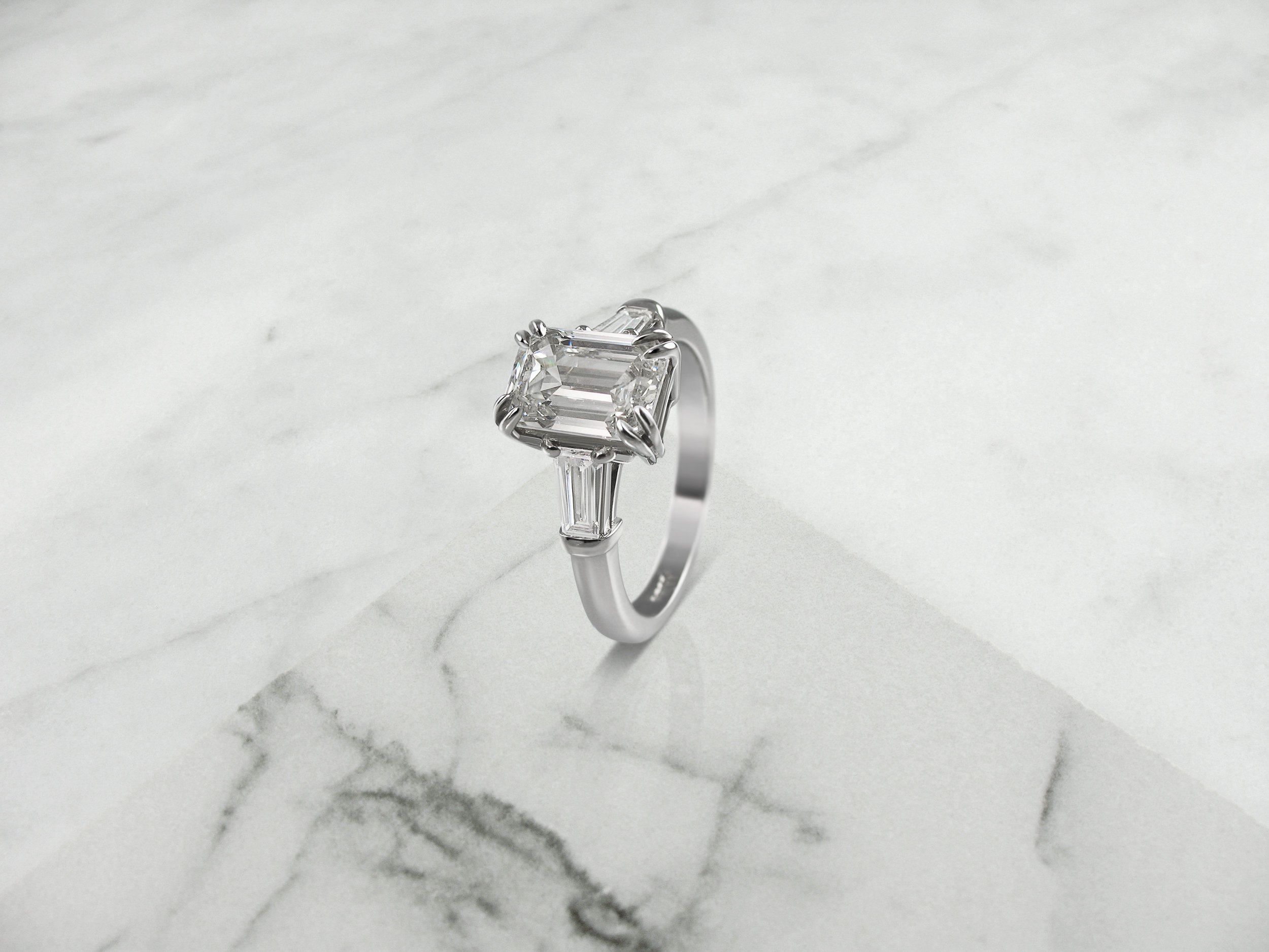 Emerald cut diamond and tapered baguette engagement ring