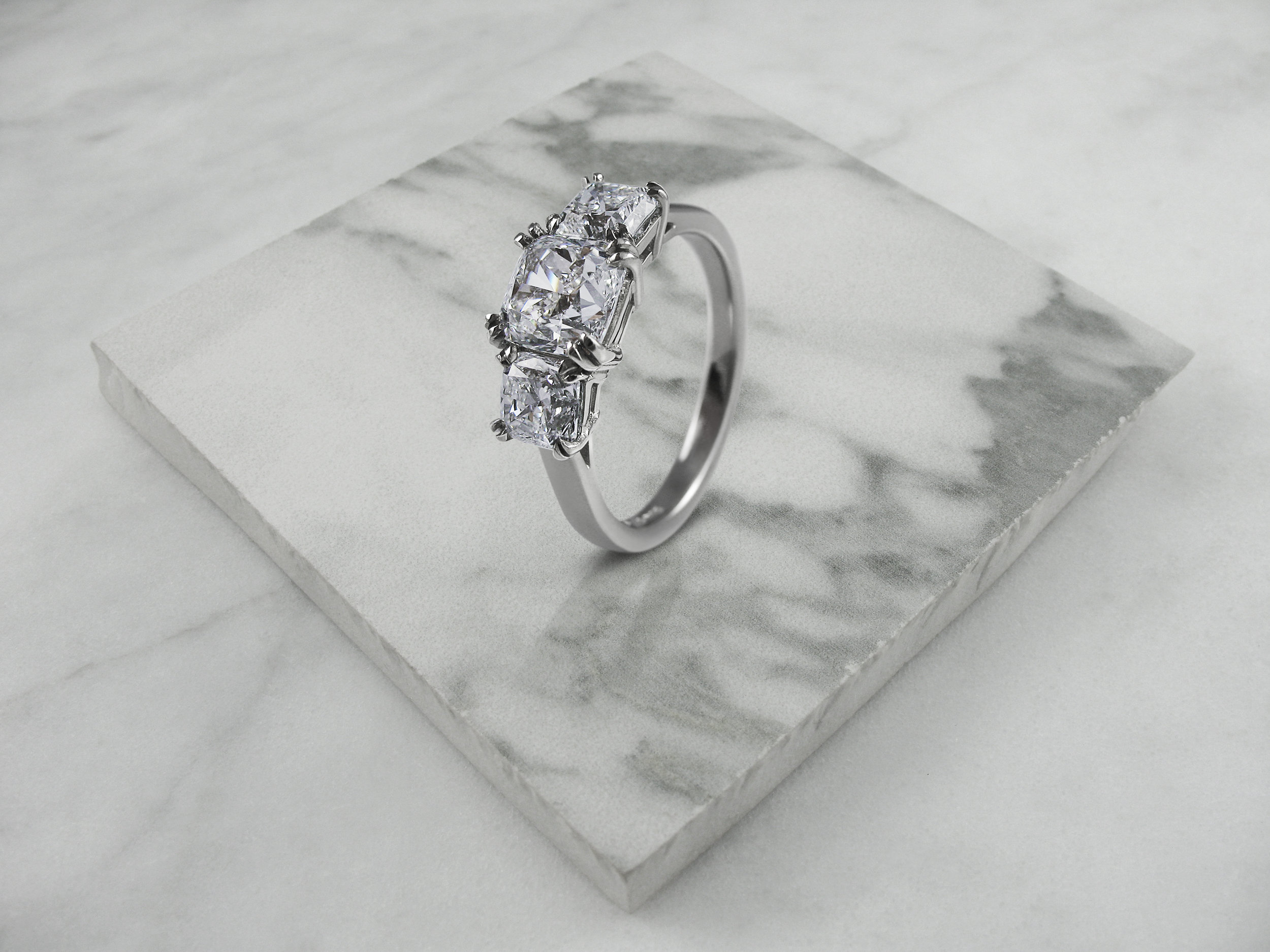 Cushion cut diamond trilogy engagement ring