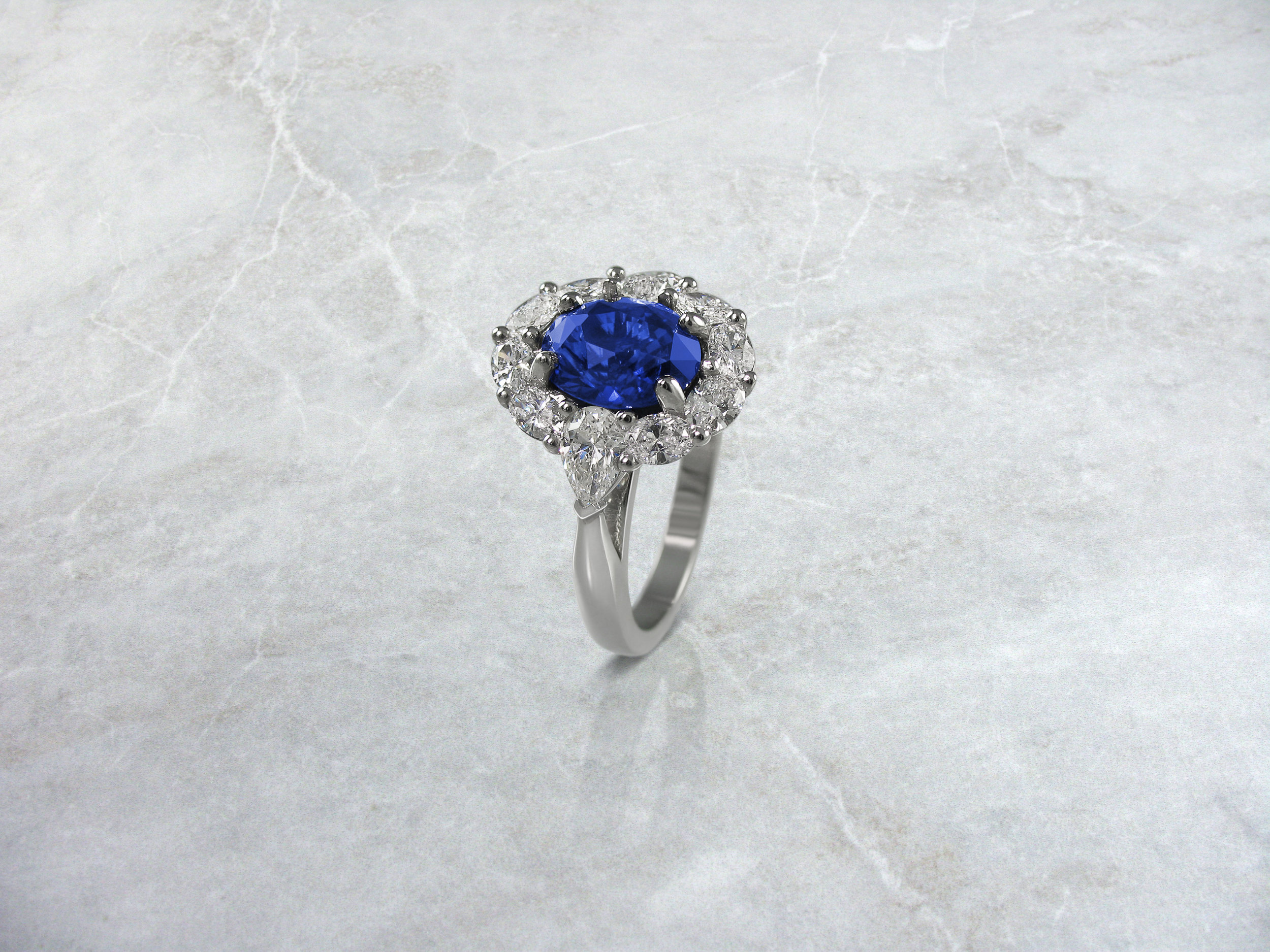 Oval sapphire and diamond cluster engagement ring with pear shaped side diamonds