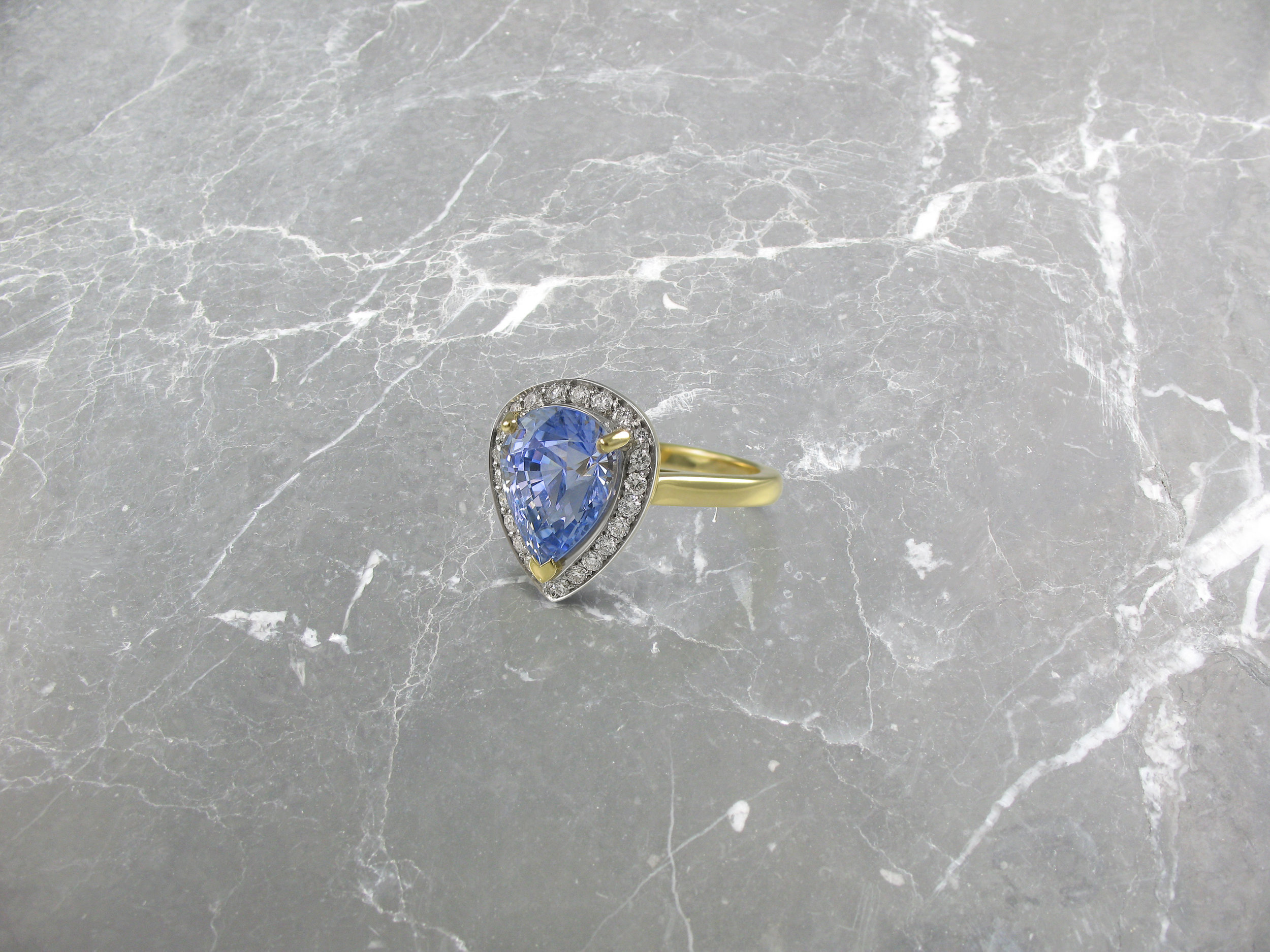 Pear shaped sapphire and diamond yellow gold halo engagement ring