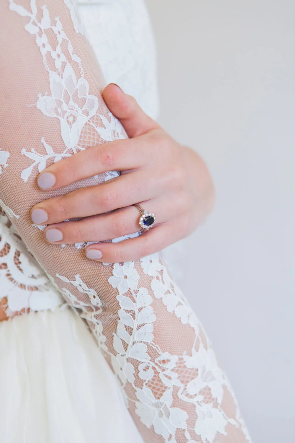 Bride's hands with sapphire engagement ring