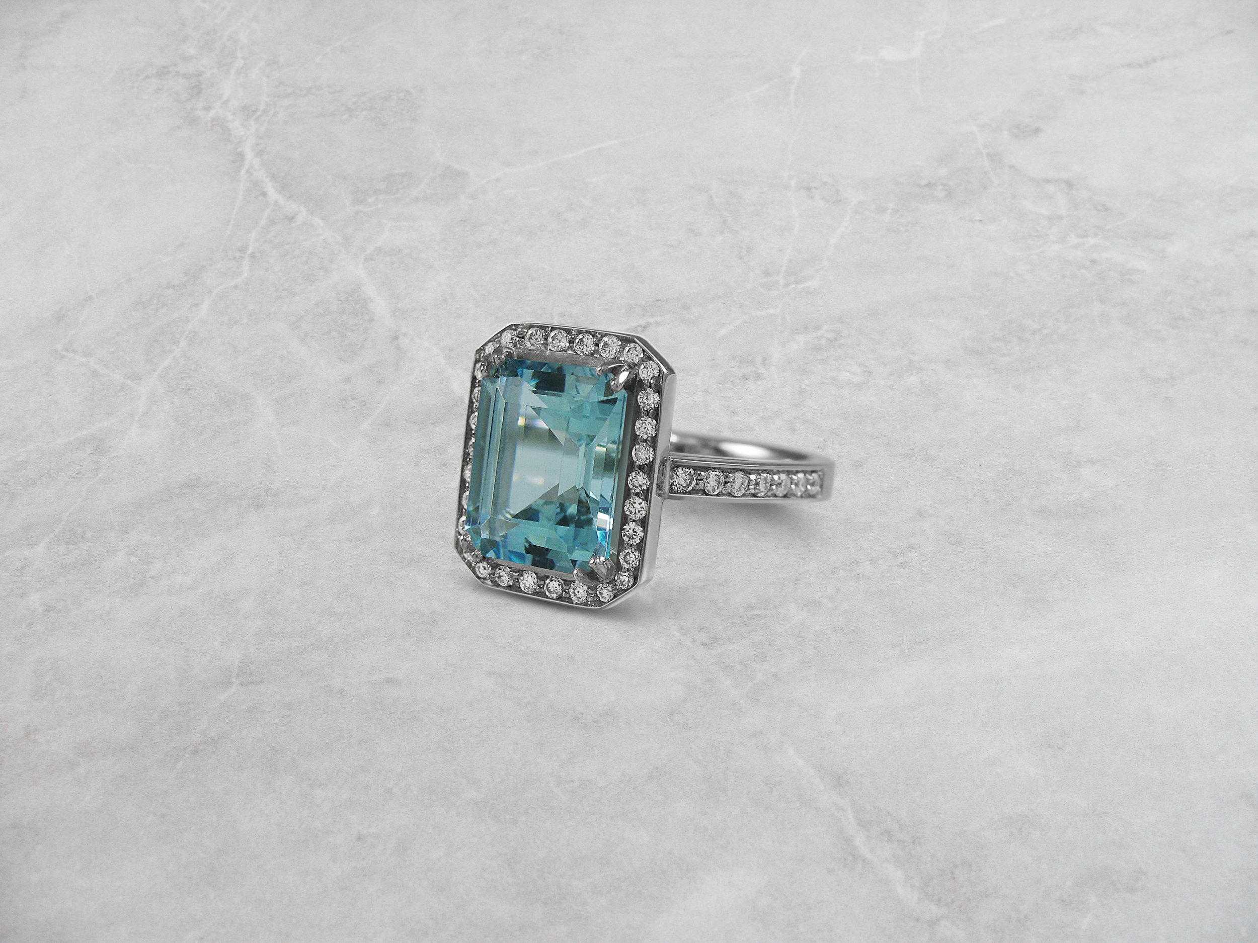 Aquamarine and diamond halo ring with double claws.jpg