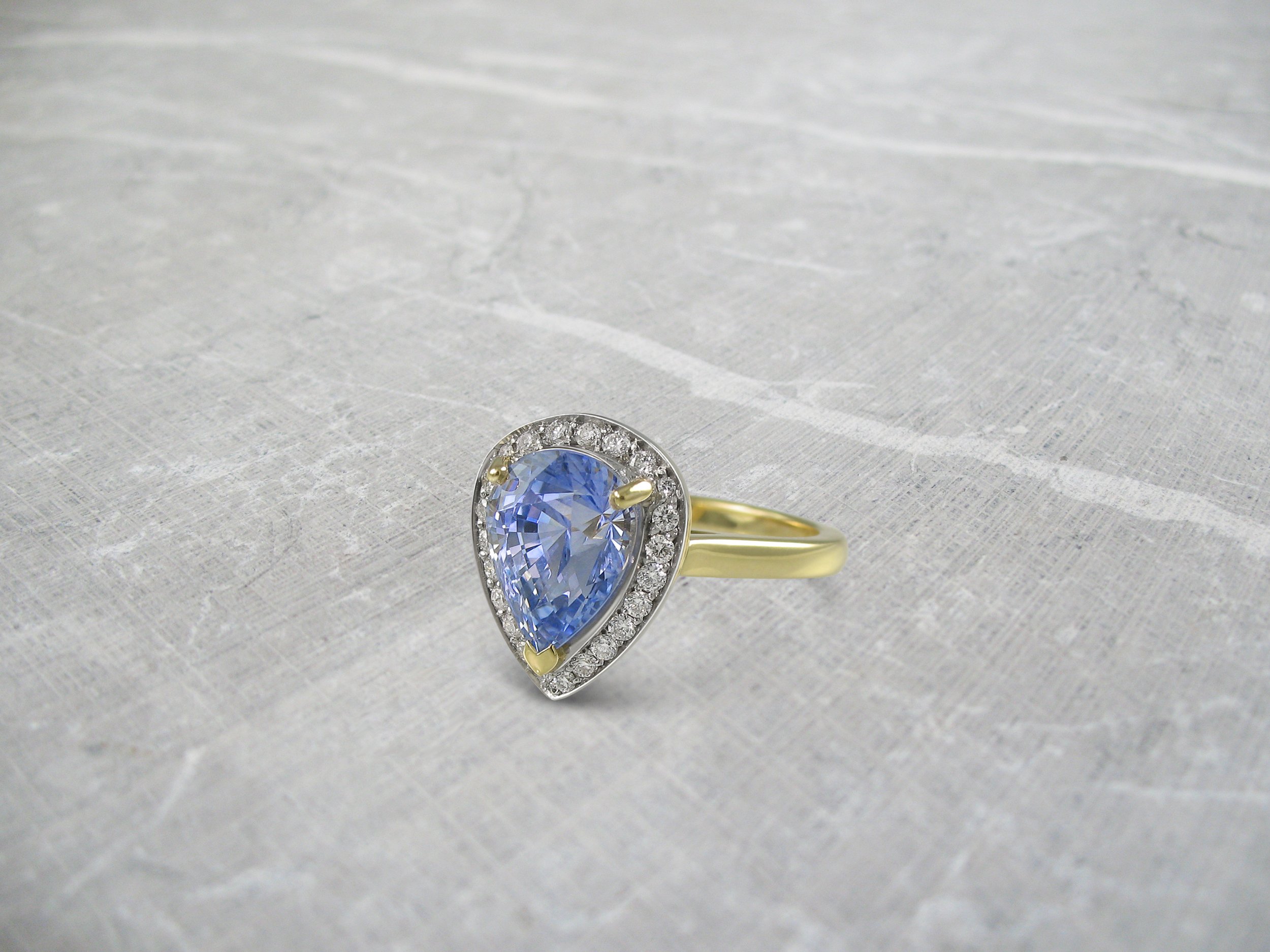 Light blue pear shaped sapphire halo ring