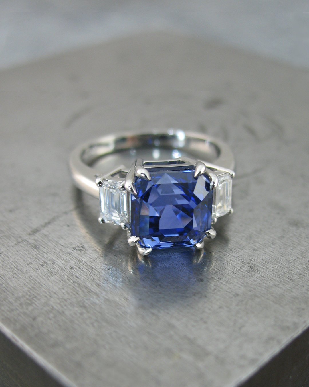 A captivating emerald cut diamond and cushion cut sapphire ring