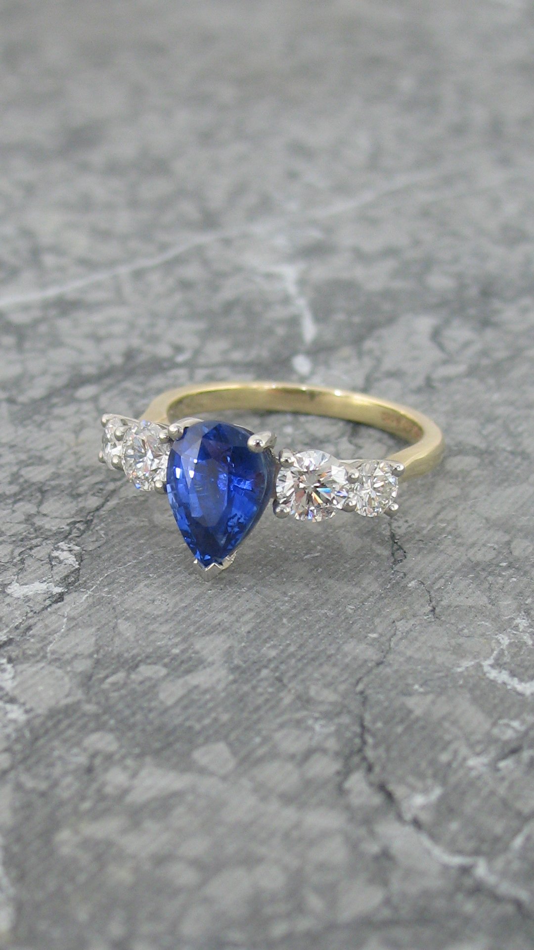 An alluring pear shaped blue sapphire and diamond engagement ring
