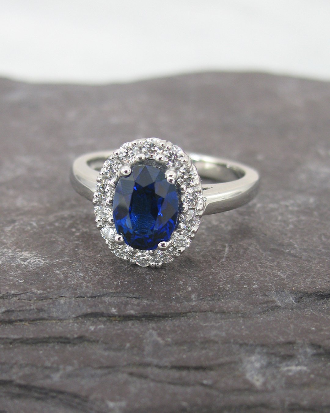 A bespoke blue oval sapphire halo ring