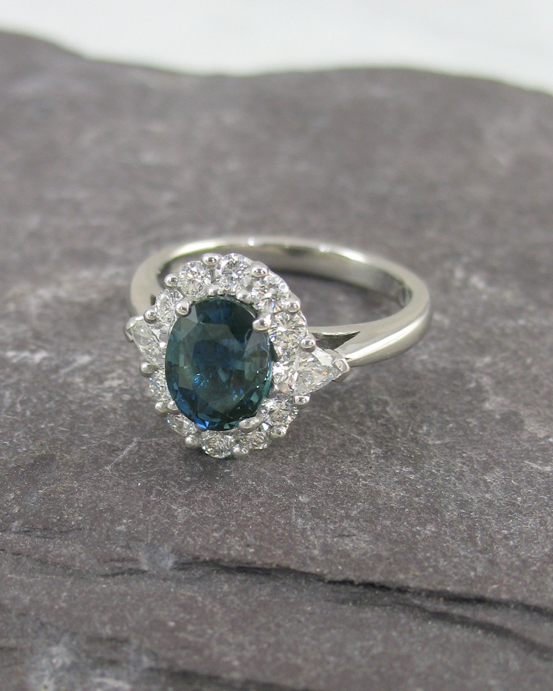 A platinum diamond and teal sapphire cluster ring