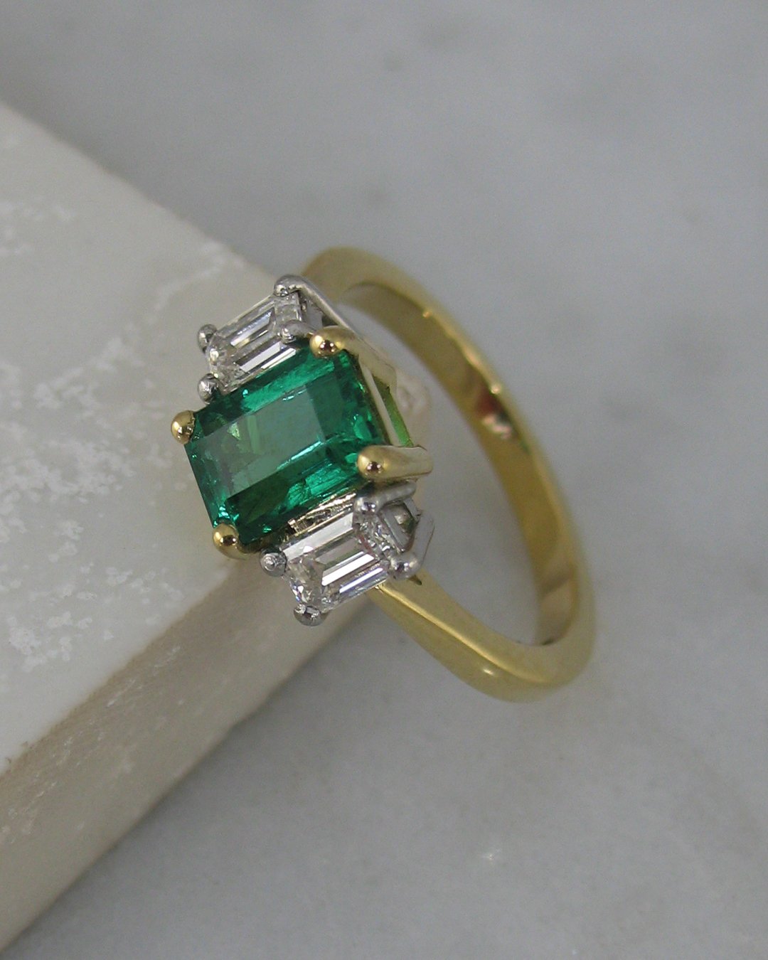 A classic three stone emerald engagement ring