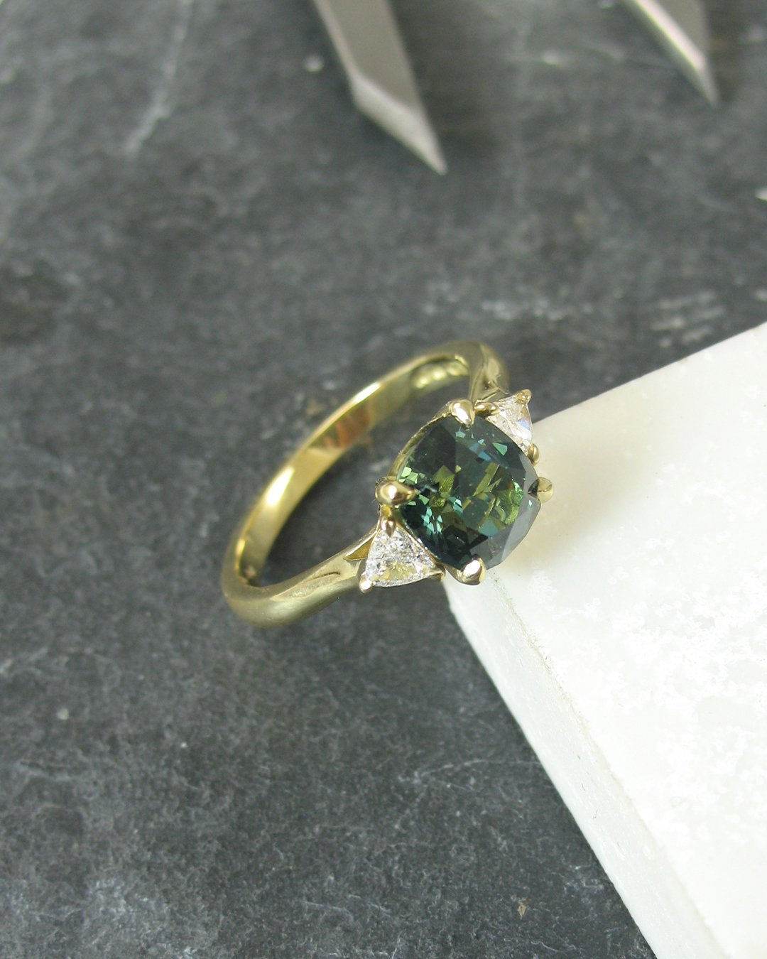 An attractive teal sapphire engagement ring