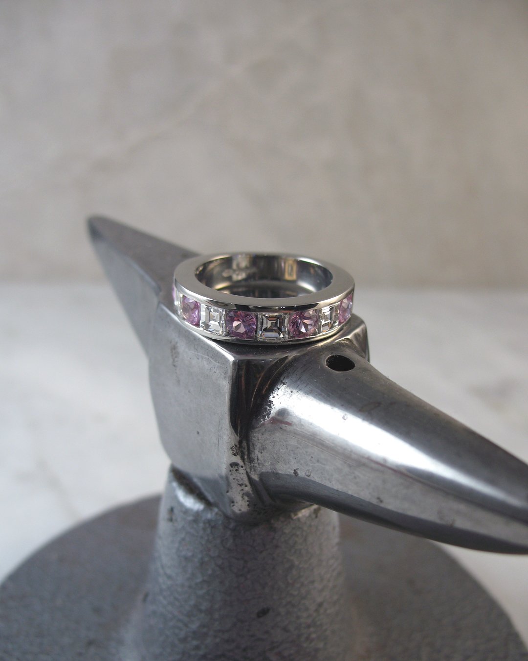 A channel setting carré cut diamond and purplish pink sapphire ring