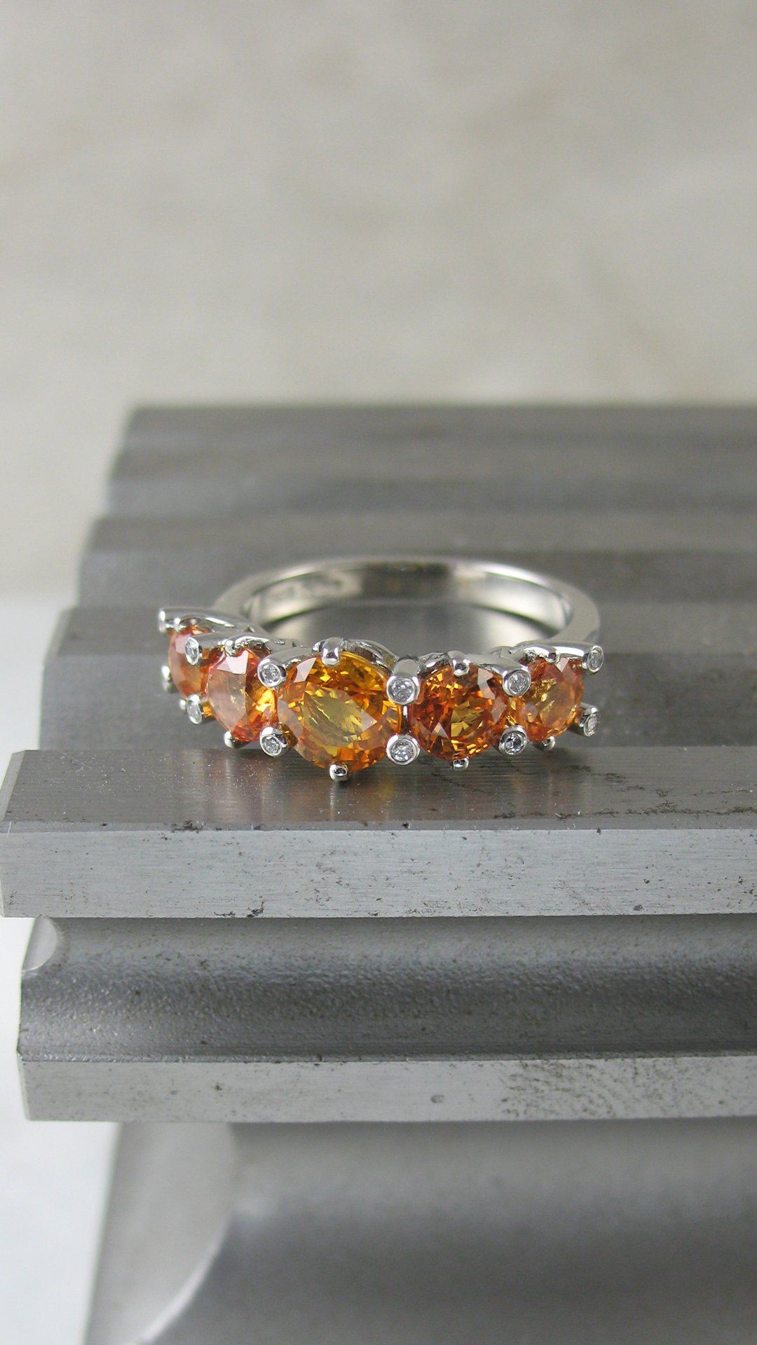 A captivating diamond and fiery orange sapphire engagement ring