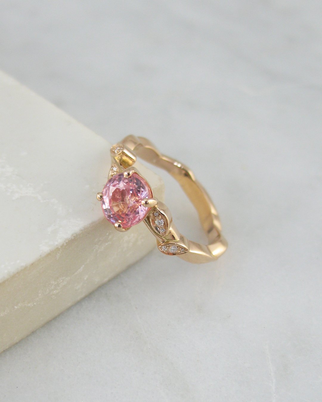 A stunning natural oval Padparadscha sapphire engagement ring