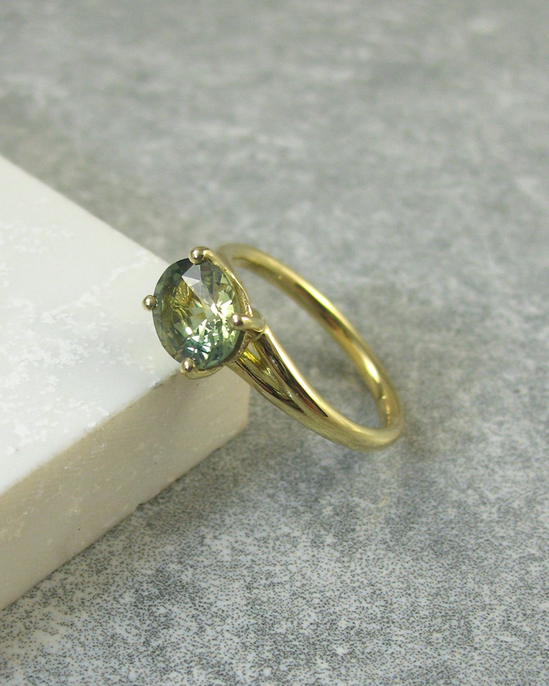 A stunning green blue bespoke sapphire engagement ring 