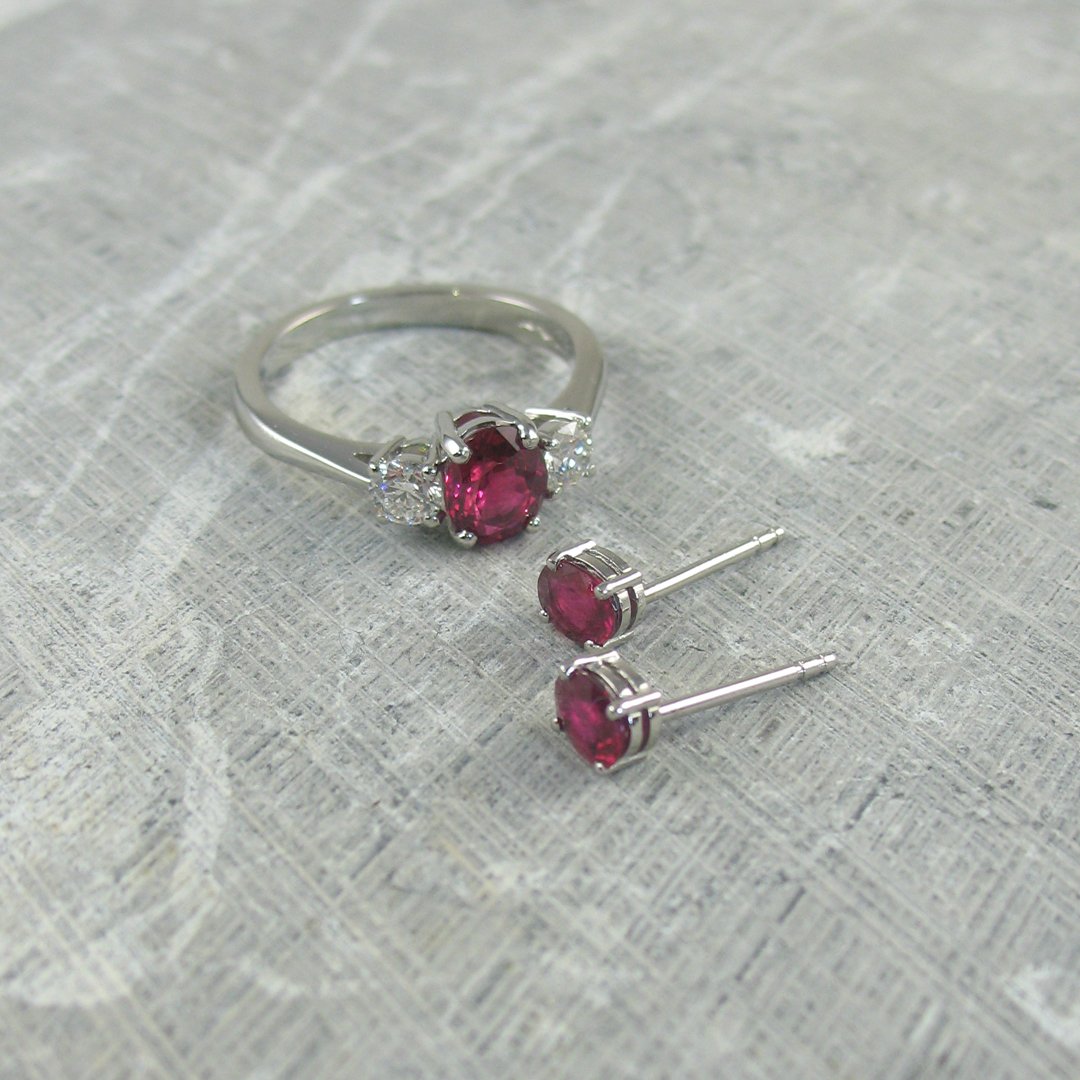 A bespoke ruby engagement ring and matching pair of rub stud earrings