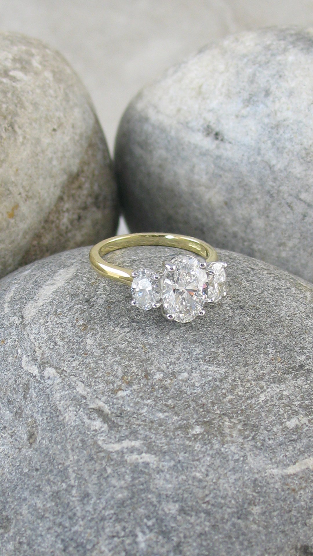 A bespoke oval diamond trilogy engagement ring