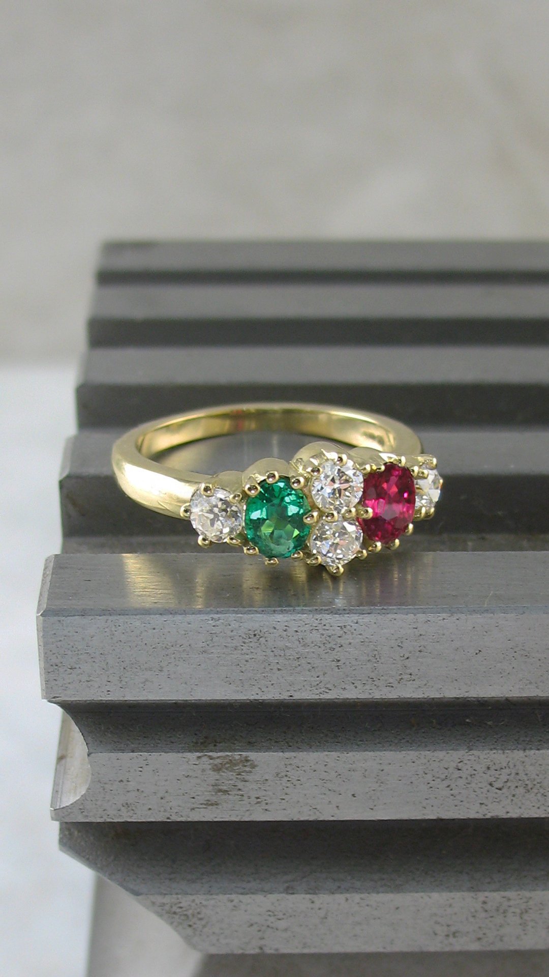 A stunning vintage inspired diamond, ruby and emerald engagement ring