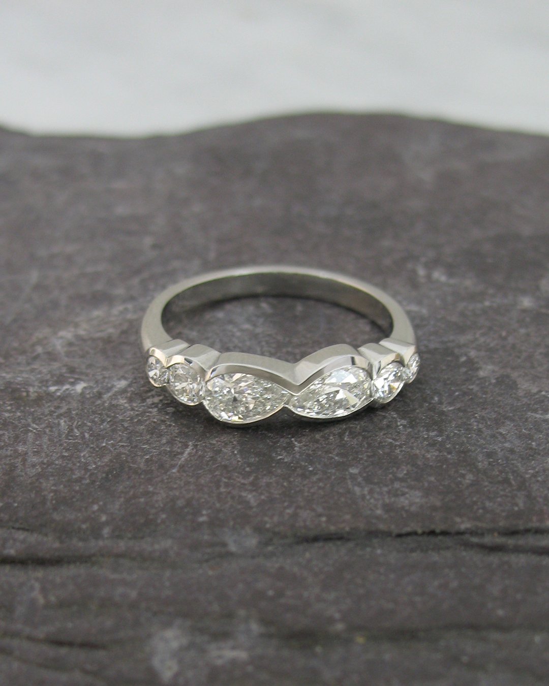 A modern point to point pear shaped diamond engagement ring