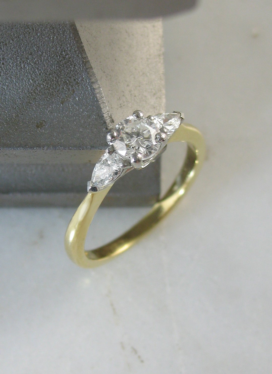 A beautiful round brilliant and pear cut diamond trilogy engagement ring