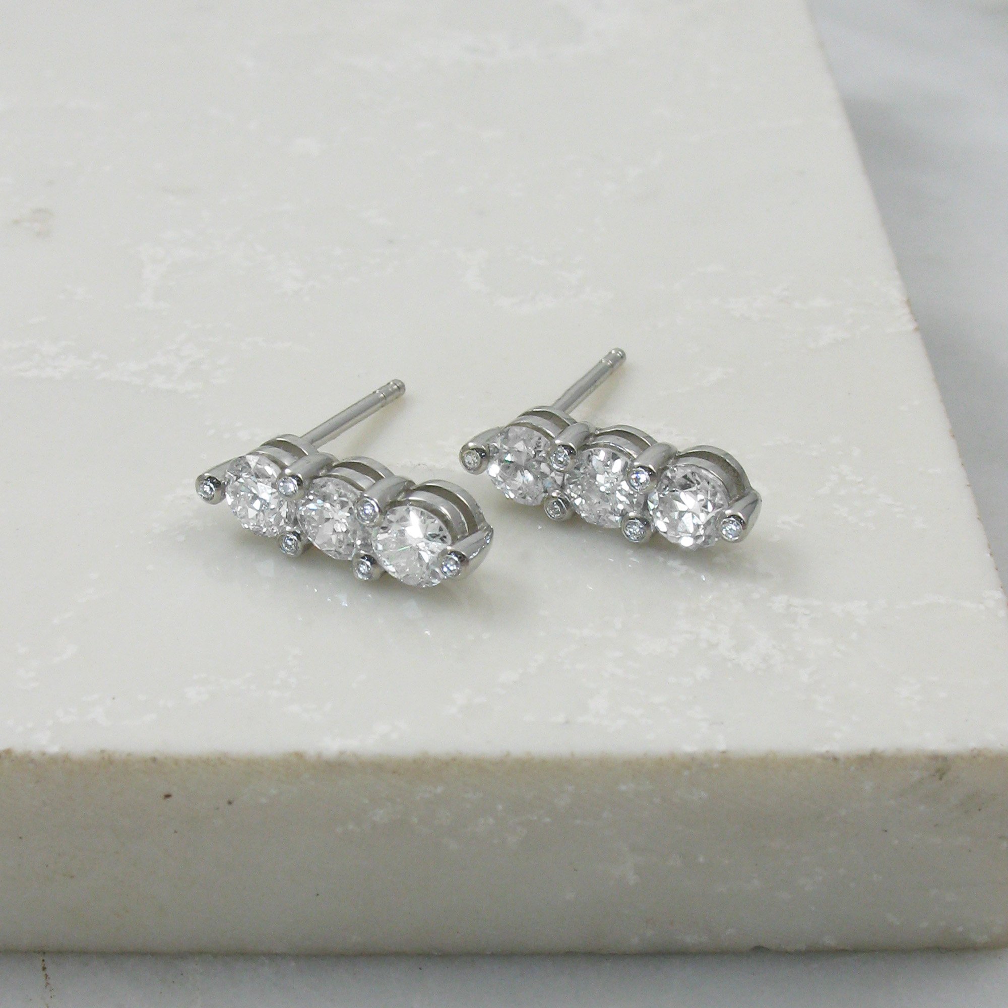 A pair of bespoke three stone diamond drop earrings