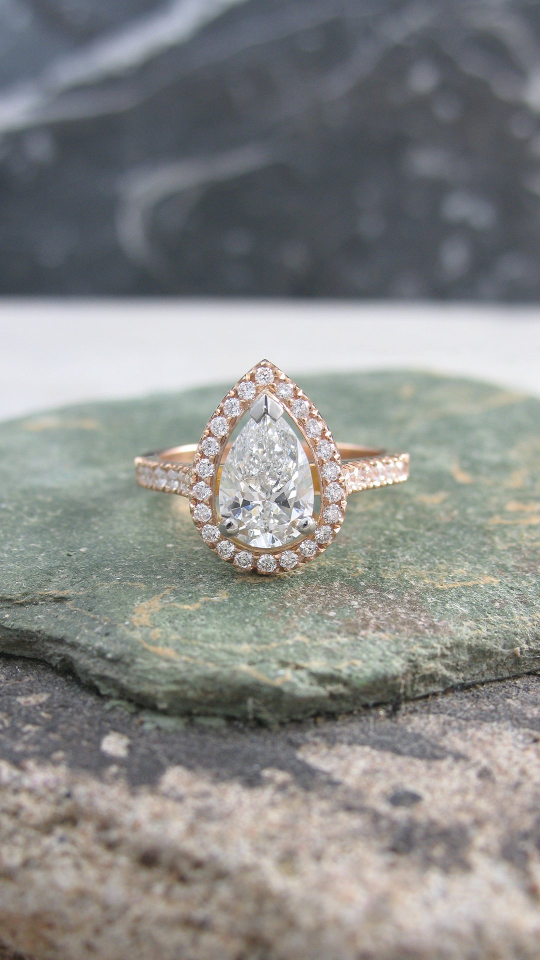 A rose gold pear shaped halo diamond engagement ring