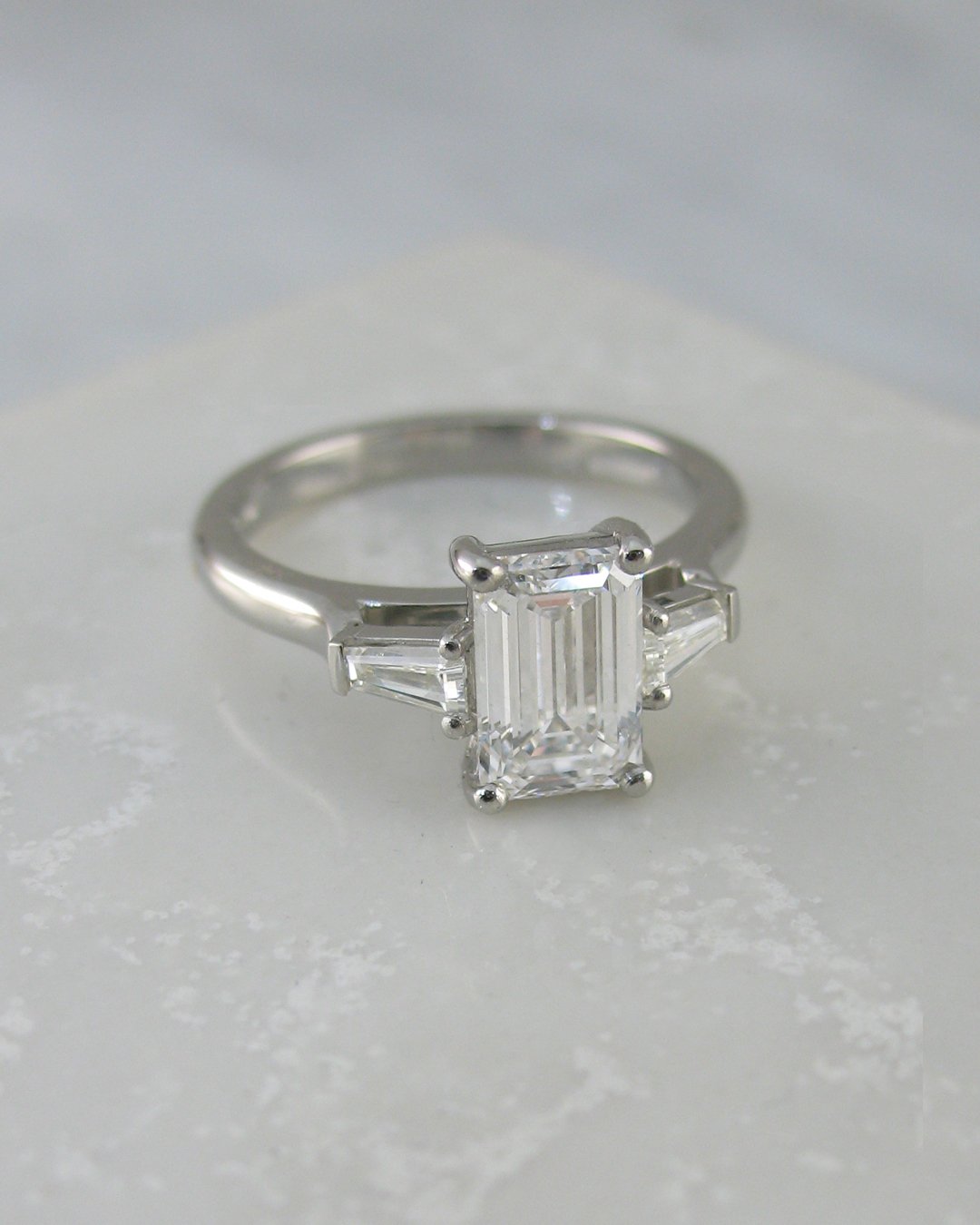 An Art Deco style emerald cut diamond engagement ring