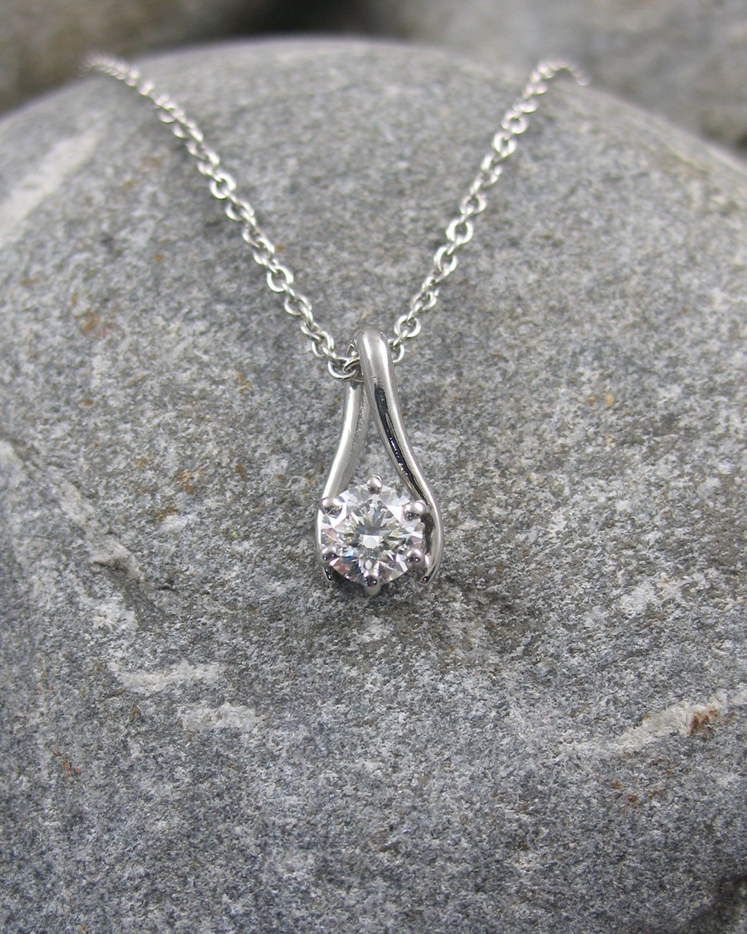A platinum six claw diamond drop pendant