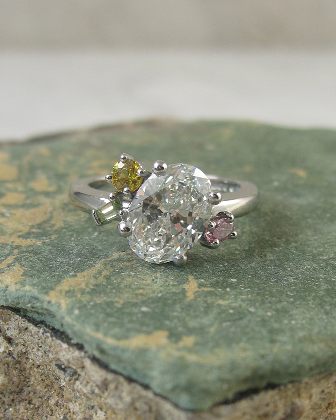 A  yellow sapphire and green white and pink custom diamond ring