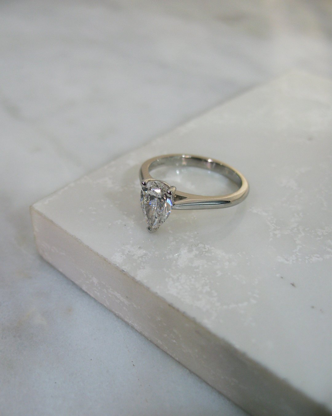  A pear shaped custom diamond engagement ring set in platinum