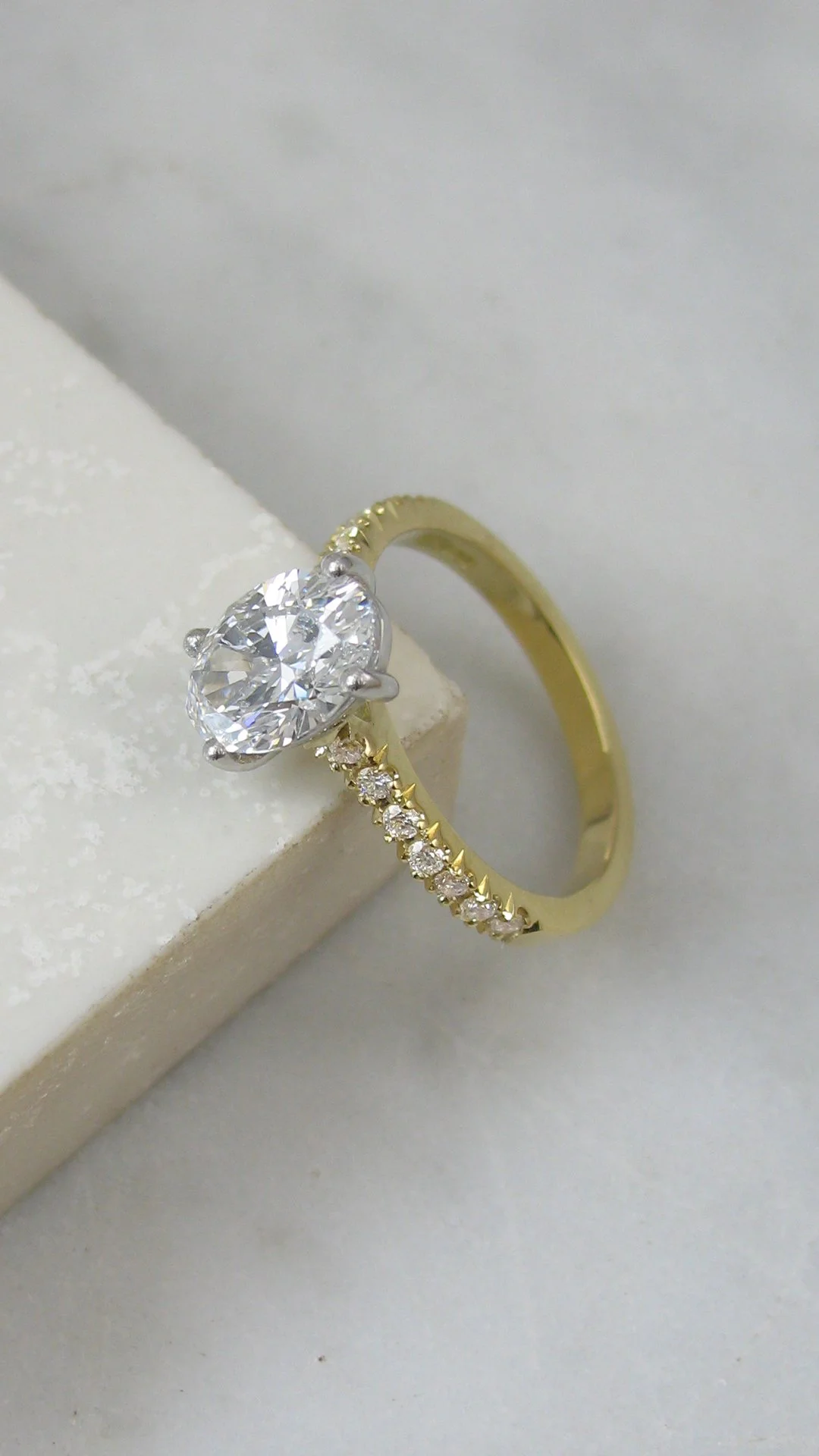 Oval diamond engagement ring with round brilliant diamonds set along the band