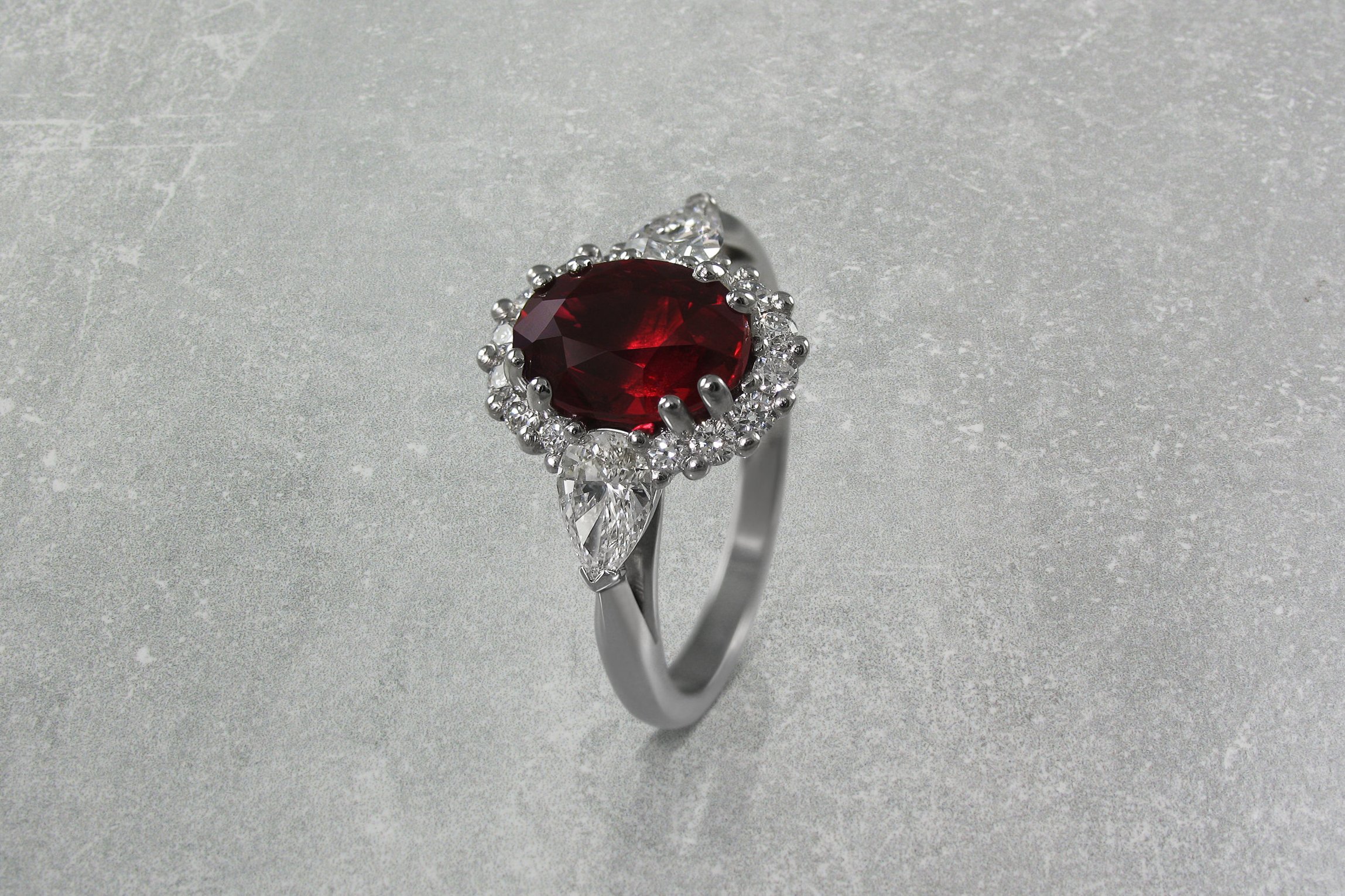 oval+ruby+and+diamond+cluster+engagement+ring+with+pear+shaped+diamond+shoulders+2.jpg