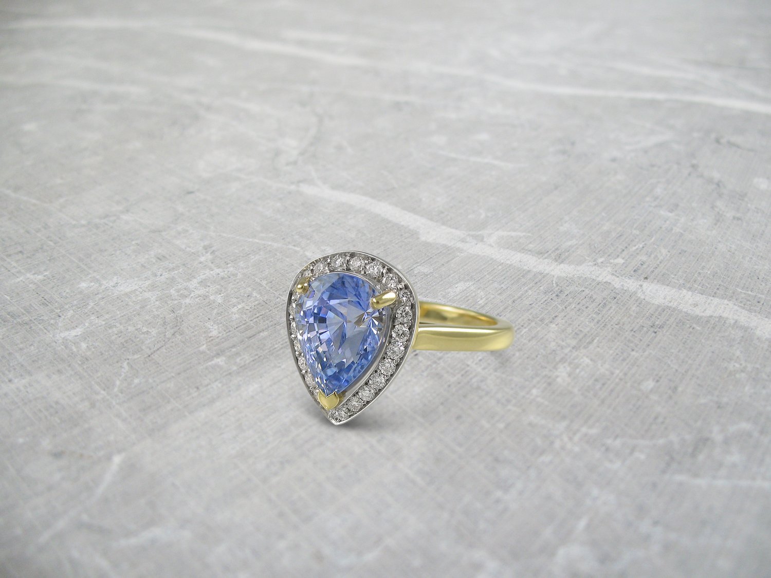 Pear shaped sapphire and diamond yellow gold halo engagement ring