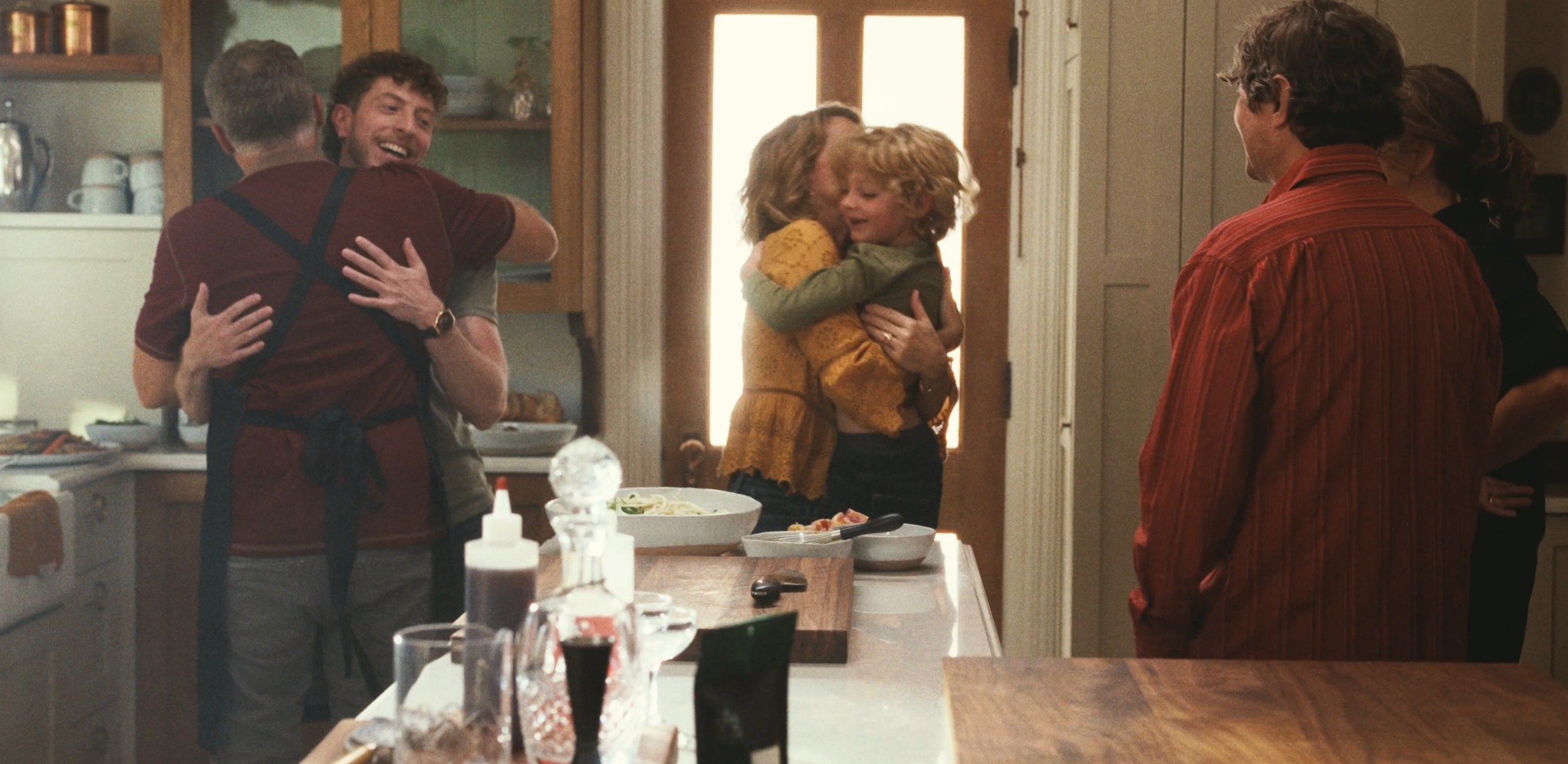 Family greeting in kitchen for dinner party.png