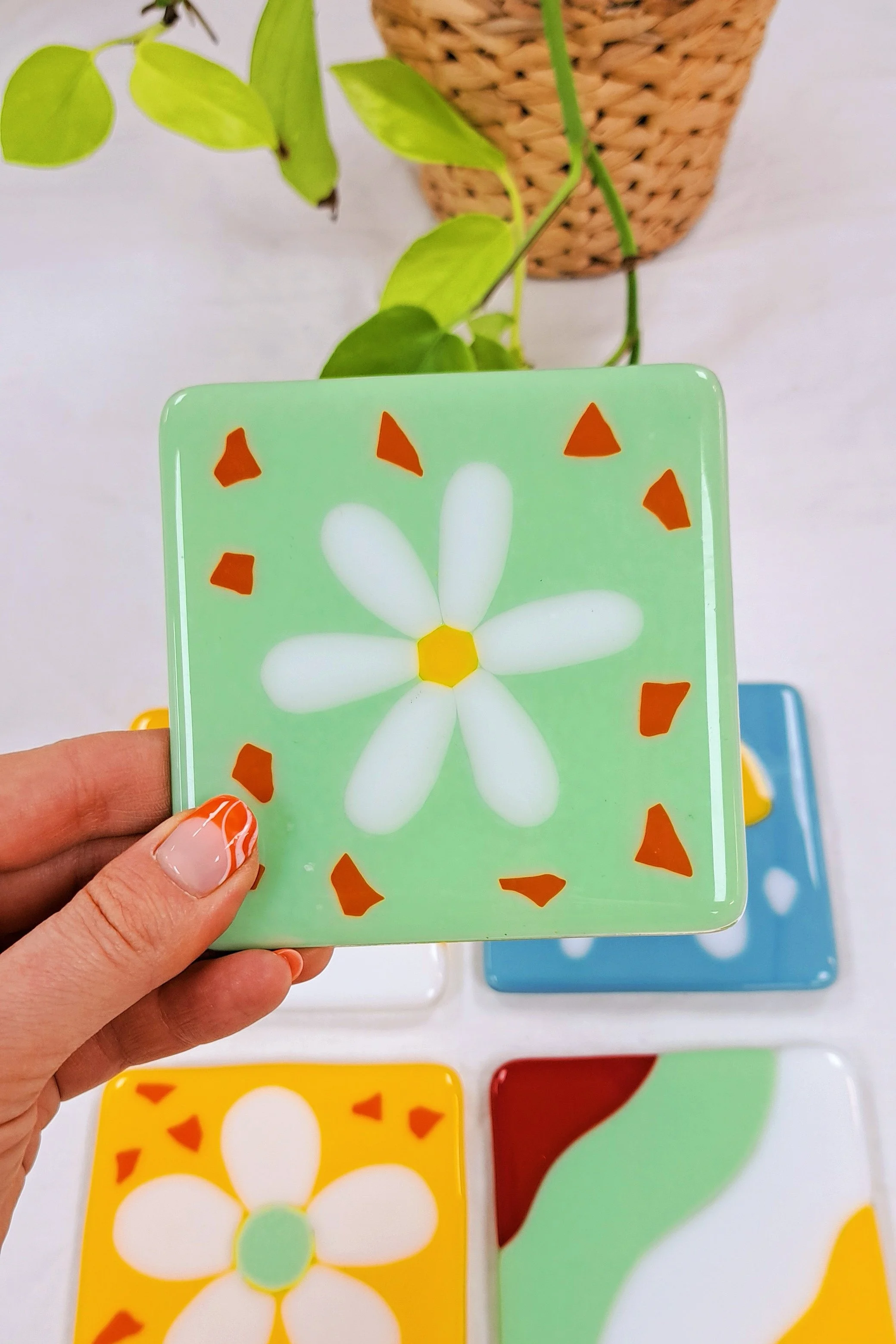 Handcrafted fused glass coaster with a colorful flower design, perfect for home decor.