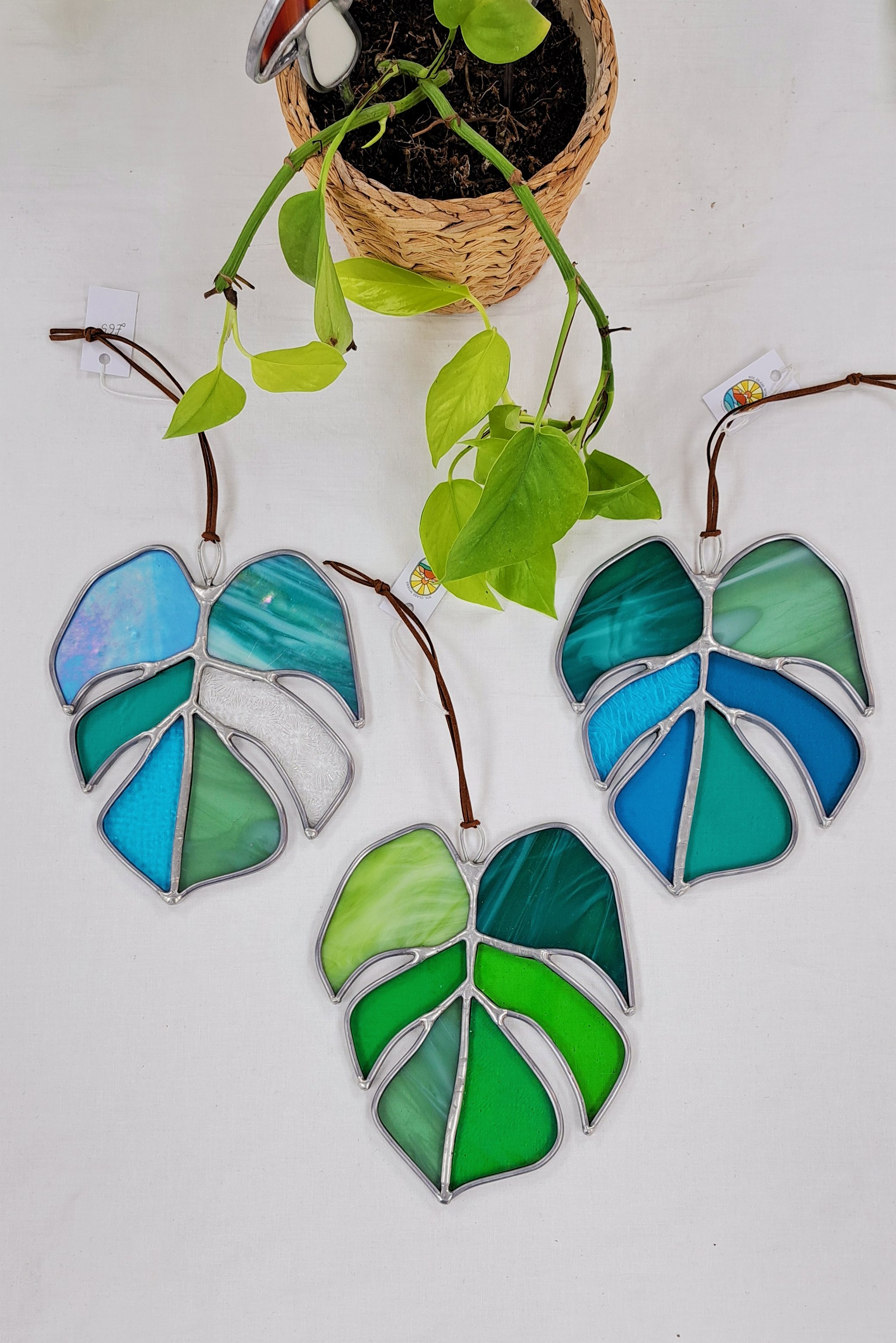 Stained glass monstera leaf suncatcher, handmade in London by Sol Glass Works, featuring vibrant green hues and a unique design, perfect for enhancing window decor.