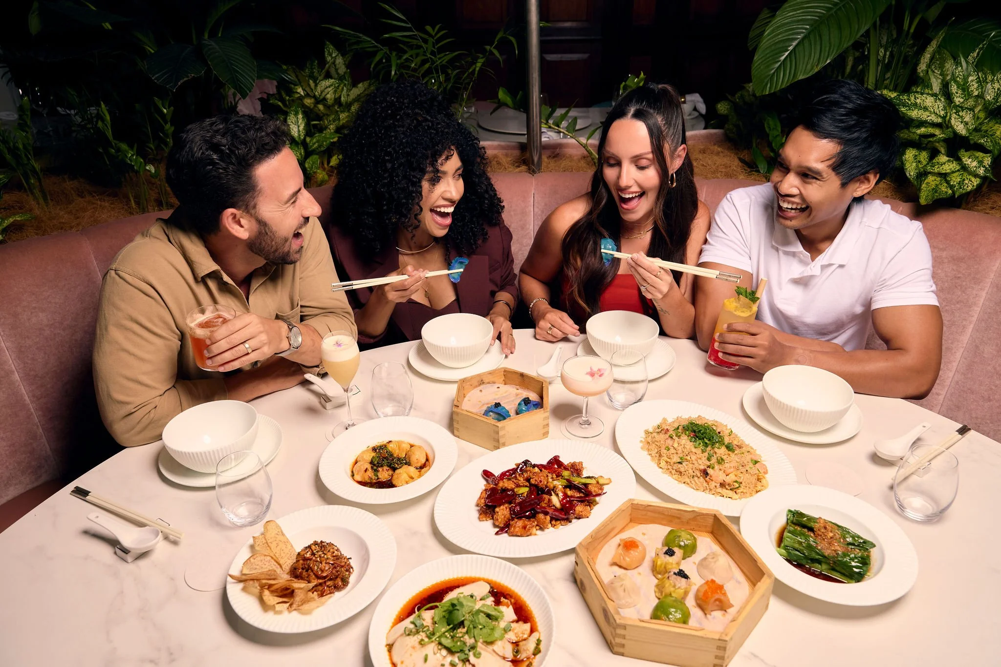 Friends sharing dumplings, cocktails and Chinese dishes at a Brisbane restaurant