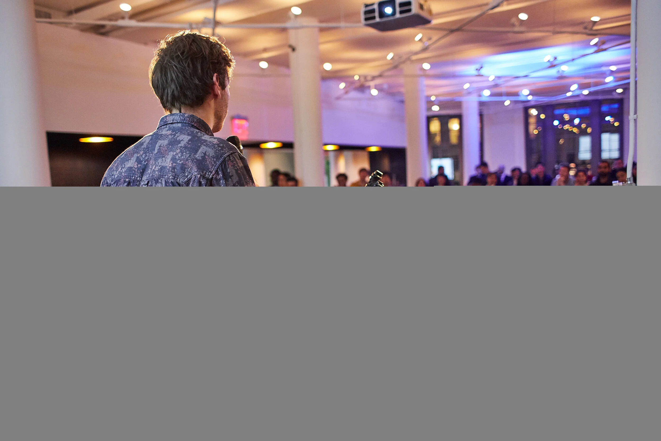 founder-presenting-from-podium-to-large-crowd.jpeg