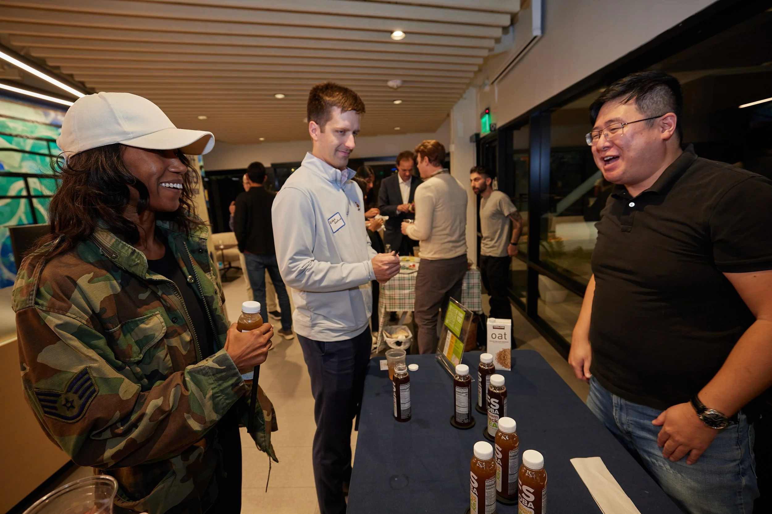 three-people-chatting-at-beverage-sampling-table.jpeg
