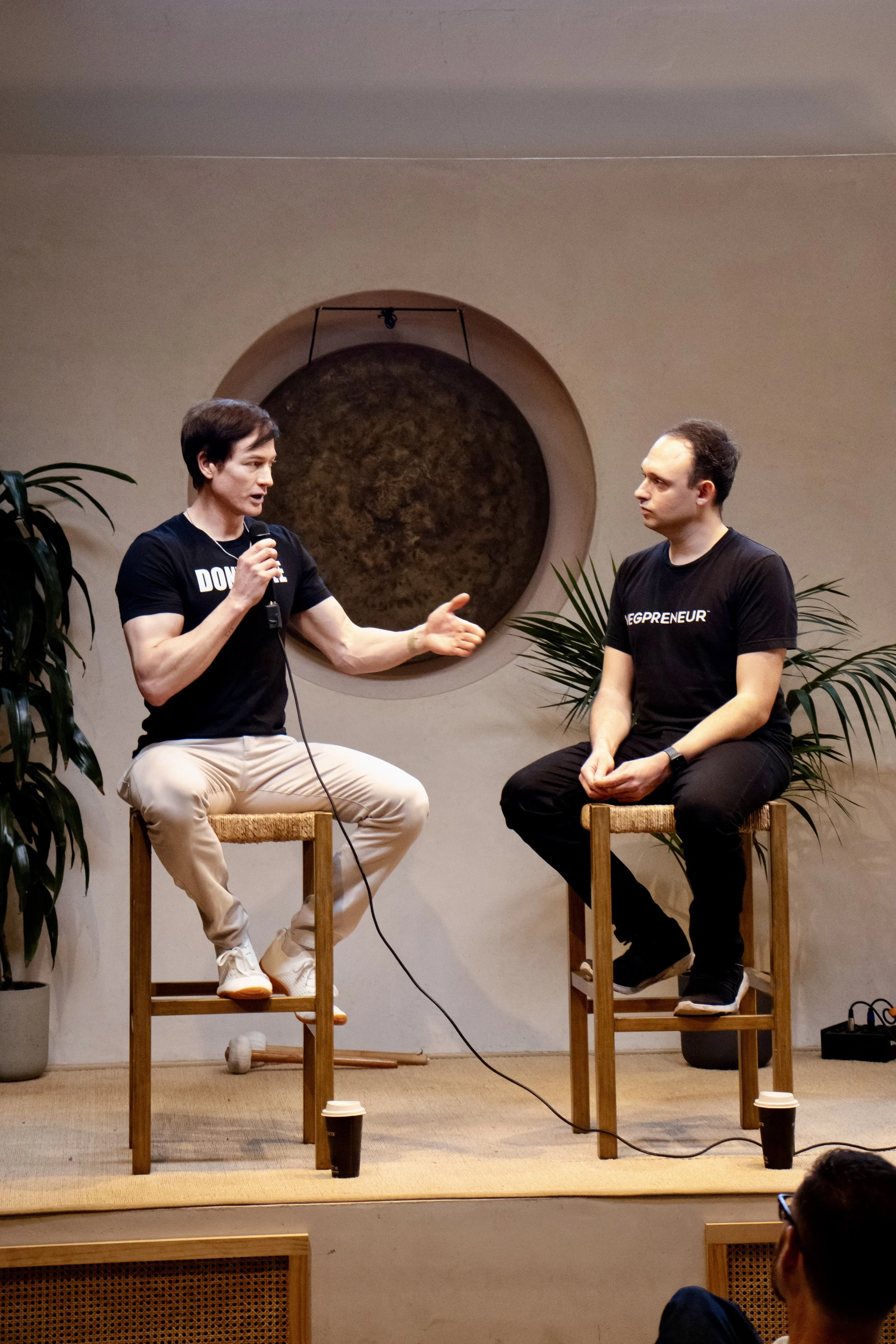 two-men-fireside-chat-on-stage.jpeg