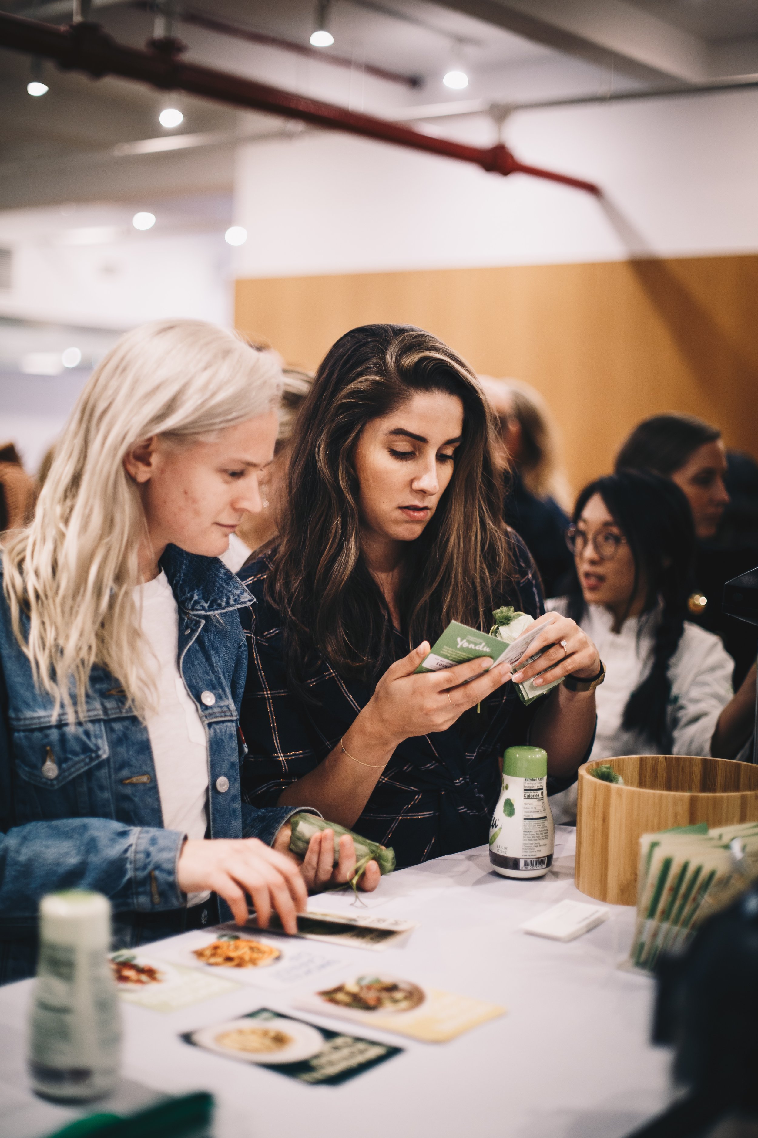 two-women-examining-products-at-tasting-table.jpeg