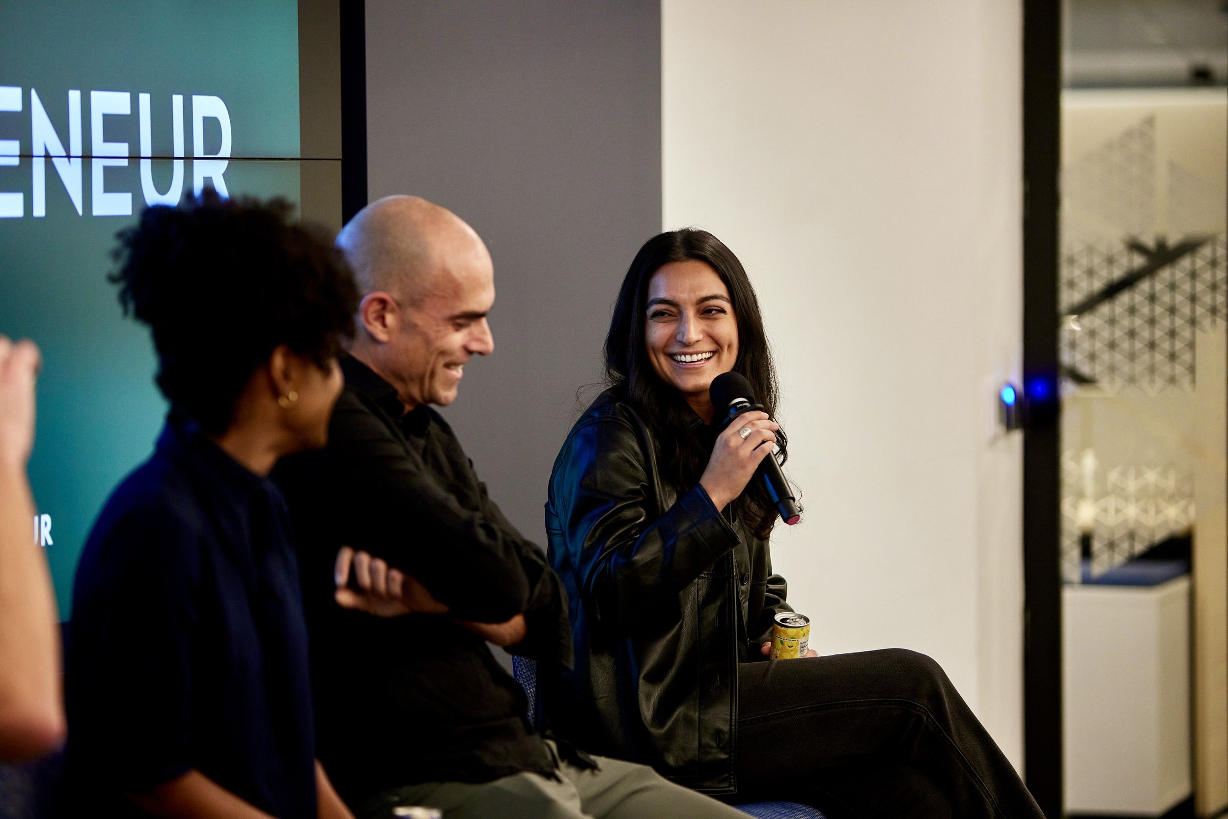 woman-speaking-on-panel-with-mic.jpeg