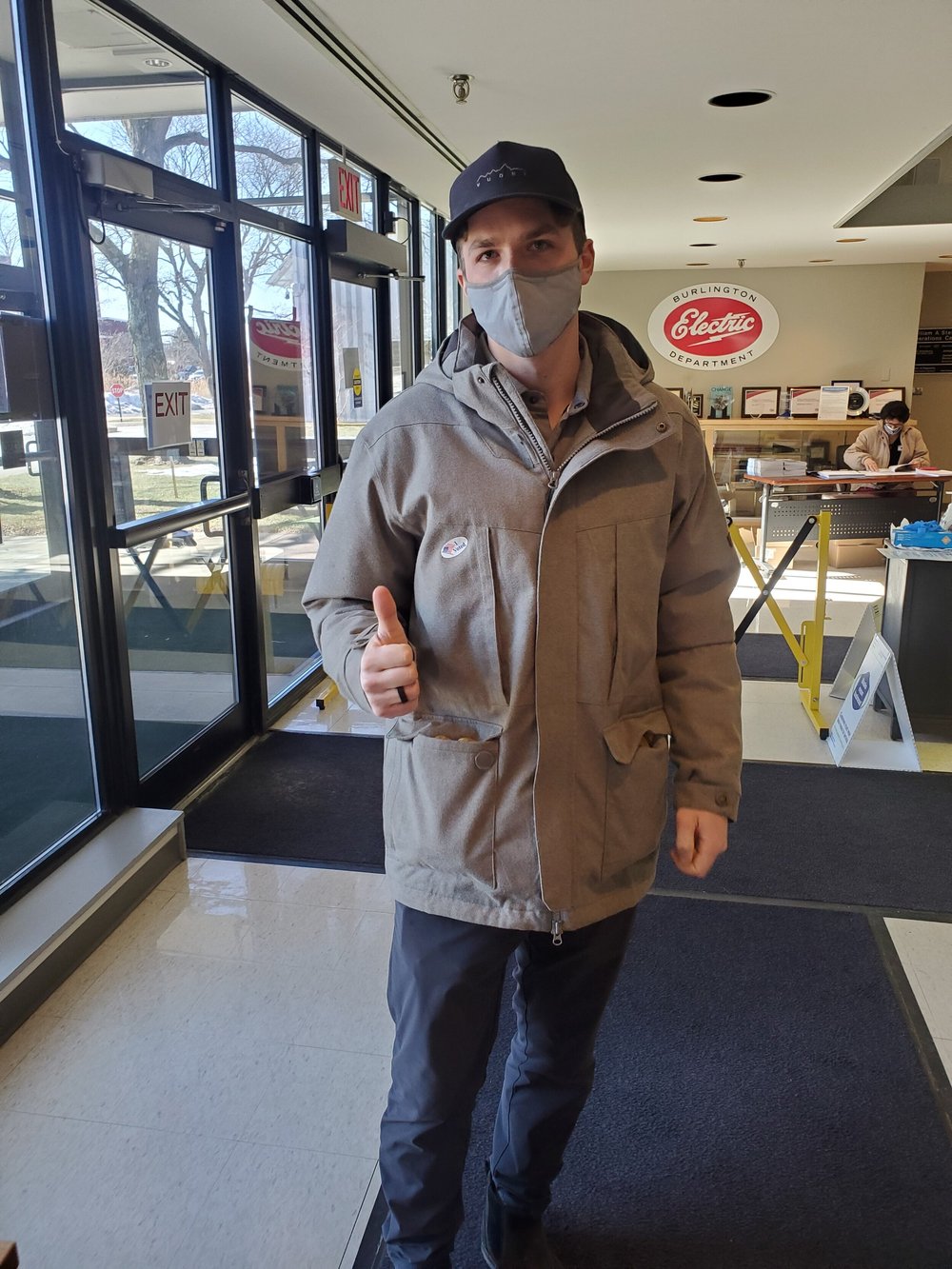 Mac Atkins, a worker in accounting, Gives a thumbs up proudly wearing his newly acquired “I voted” sticker on his jacket. (Chris Meunier/Community News Service)