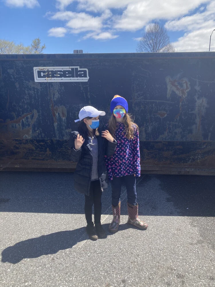 Johana and Naomi pose in front of the dumpster after throwing away what they had collected from Mayfair Park on Saturday May 1, 2021. ( Aidan Scanlon/Community News Service )