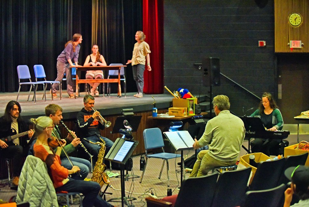   The orchestra joins in for the final rehearsals. Left to right: Daniel Gaviria on guitar; Sofia Hirsch on violin; Dan Liptak playing clarinet; Jason Whitcomb on trumpet; with Conductor Chris Rivers and Stefanie Weigand on keyboard. Photo by Gordon 