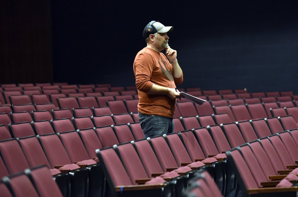   Director Scott Weigand takes in the scene from the auditorium seats. Photo by Gordon Miller.  
