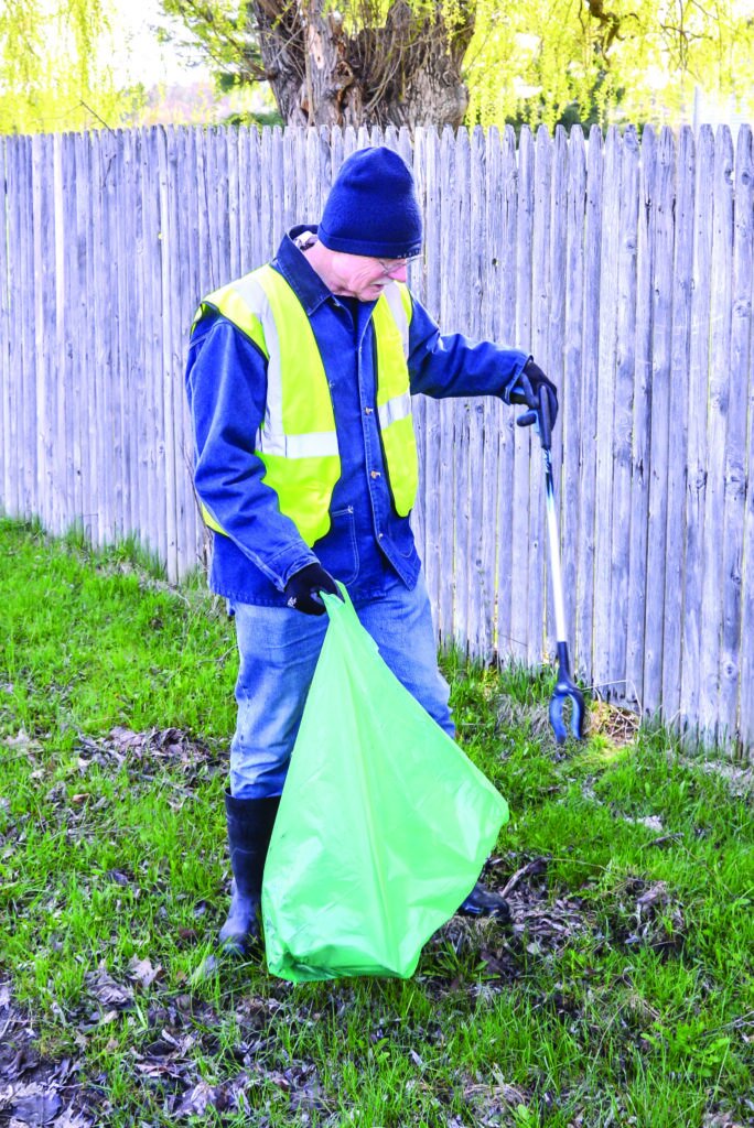  John Butterfield cleans up along North Williston Road on Green Up Day in Williston on Saturday. 