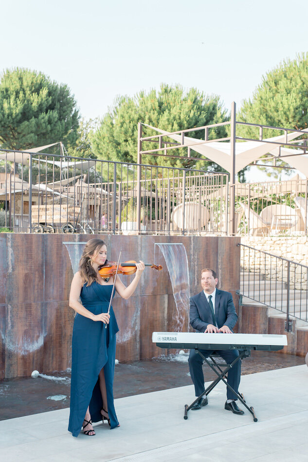 Orchestre avec violoniste et pianiste jouant pendant le cocktail.