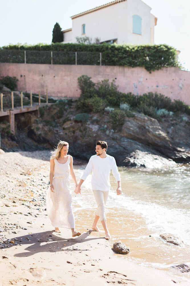 Séance engagement à Toulon au bord de mer, couple marchant sur la plage.